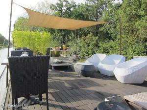 un patio con tavoli, sedie e tenda di Péniche Mirage a Carcassonne