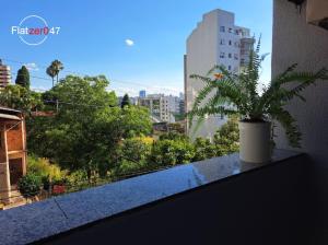 a potted plant sitting on a ledge on a balcony at Flatzer047 Executivo in Caxias do Sul