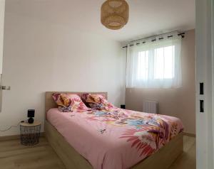a bedroom with a bed with pink sheets and a window at Appart COSY F2 Disneyland/Val d'Europe in Montévrain