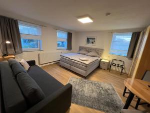 a living room with a couch and a bed at Gästezimmer Kirchdorf in Unteropfingen