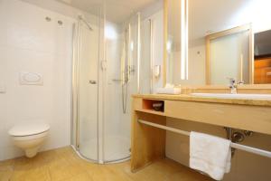 een badkamer met een douche, een toilet en een wastafel bij Falkensteiner Club Funimation Borik in Zadar