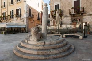 a statue in the middle of a courtyard at house green station in Bari