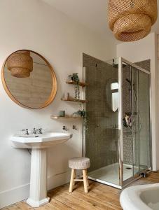 een badkamer met een wastafel, een douche en een spiegel bij Malie & Macha - Jolie Maison à Malo-les-Bains in Duinkerke