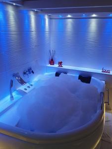 a large white bath tub in a bathroom with blue lighting at B&B Maryflower in Naples