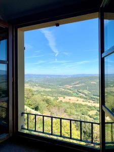een raam met uitzicht op het landschap vanuit een huis bij Appartamento con vista panoramica in Campagnatico