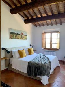 sypialnia z dużym białym łóżkiem z żółtymi poduszkami w obiekcie Appartamento con vista panoramica w mieście Campagnatico
