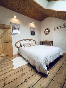 een slaapkamer met een groot bed en een houten vloer bij Malie & Macha - Jolie Maison à Malo-les-Bains in Duinkerke