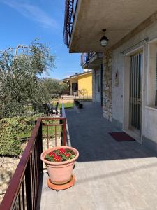 una maceta de flores sentada en el porche de una casa en Casa Bruna, 3-room apartment with private garden, en Torri del Benaco