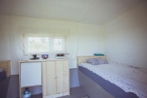Habitación pequeña con cama y ventana en Lake Peipsi boathouses en Varnja