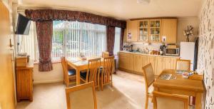 a kitchen with a table and a dining room at Blythewood Guest House in Coleshill