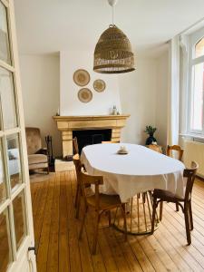 jadalnia ze stołem, krzesłami i kominkiem w obiekcie Malie & Macha - Jolie Maison à Malo-les-Bains w mieście Dunkierka