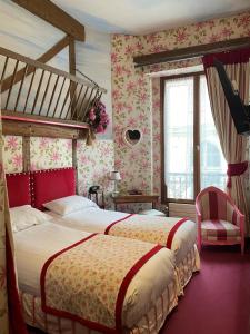 a hotel room with two beds and a chair at Grand Hôtel Dechampaigne in Paris