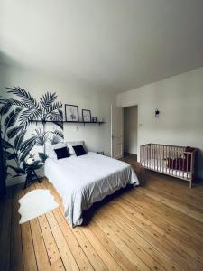 1 dormitorio con 1 cama y una planta grande en Malie & Macha - Jolie Maison à Malo-les-Bains en Dunkerque