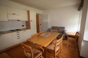 uma cozinha e sala de jantar com uma mesa de madeira e cadeiras em Casa Nembia em San Lorenzo in Banale