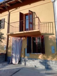 a building with a balcony on the side of it at L'ulivo,casa di campagna. in Cortiglione
