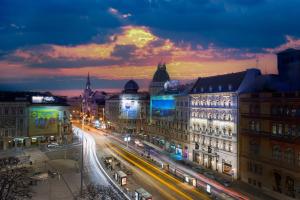 a city lit up at night with buildings and traffic at Hotel Nemzeti Budapest - MGallery in Budapest