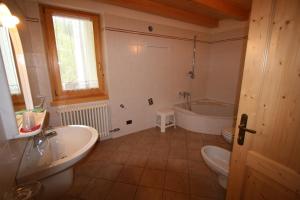 a bathroom with a tub and a sink and a toilet at Casa Nembia in San Lorenzo in Banale