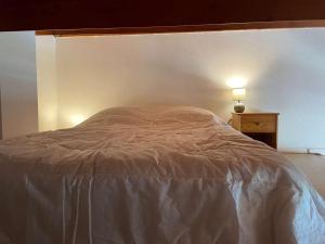 een bed met een wit dekbed in een slaapkamer bij Appartement La Rochelle, 1 pièce, 4 personnes - FR-1-246-582 in La Rochelle