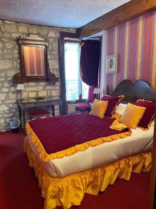 a bedroom with a large bed with yellow and red pillows at Grand Hôtel Dechampaigne in Paris
