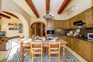 a large kitchen with a wooden table and chairs at Djar Ta Menzja 1 Holiday Home in Sannat