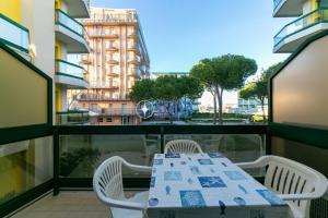 een tafel en stoelen op een balkon met uitzicht op een gebouw bij Costa Del Sol in Lido di Jesolo