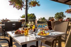 a table with breakfast food on a patio at Veramar Hotel - All Inclusive & Free Beach in Kranevo