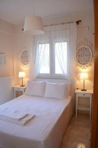 - une chambre avec un grand lit blanc et 2 fenêtres dans l'établissement Lemon Beach Front Apartment, Nikiti, à Nikiti