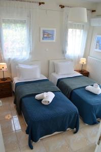 deux lits dans une chambre avec des serviettes dessus dans l'établissement Lemon Beach Front Apartment, Nikiti, à Nikiti