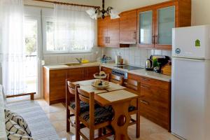 une cuisine avec une table et un réfrigérateur blanc dans l'établissement Lemon Beach Front Apartment, Nikiti, à Nikiti 27 autres photos