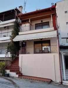 a building with a white fence and a balcony at To Spitaki in Neos Marmaras