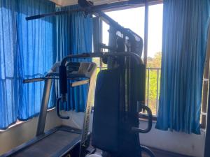 a gym with blue curtains and a treadmill at NeelRatna Bed And Breakfast in Shirdi