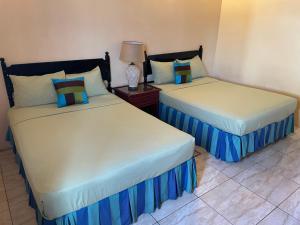 Cette chambre comprend 2 lits avec des draps bleus et blancs. dans l'établissement Shirvan Holiday Apartments One Bedroom, à Canaan