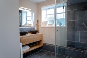 La salle de bains est pourvue d'une douche en verre et d'un lavabo. dans l'établissement Haus Boy, à Kampen