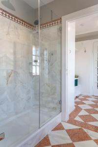 La salle de bains est pourvue d'une douche en verre et de carrelage. dans l'établissement Haus Boy, à Kampen
