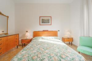 - une chambre avec un lit, une commode et un miroir dans l'établissement Casa Fiorella a Pomonte-Goelba, à Pomonte