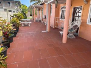 un patio con sillas, mesas y macetas en Shirvan Holiday Apartments One Bedroom, en Canaan