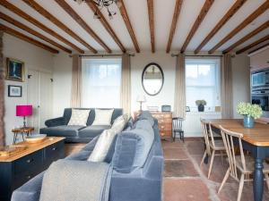 a living room with a blue couch and a table at Stag Cottage in Penrith