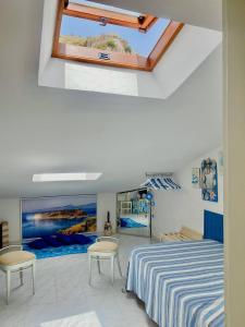 1 dormitorio con 1 cama, 2 sillas y ventana en Al Vecchio Pioppo, en Praia a Mare