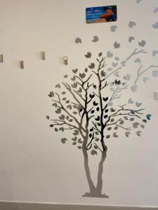 a tree with leaves and birds on a wall at Bari Lory’s Home in Bari