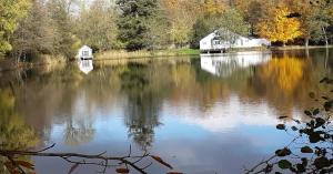 un gran lago con una casa en el medio en La cabane sur l'eau, en Cul-des-Sarts