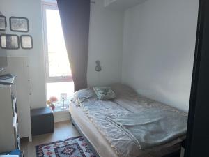 a small bed in a room with a window at Ocean view apartment in Tromsø