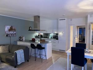 cocina y sala de estar con sofá y mesa en Ocean view apartment en Tromsø