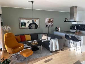 a living room with a couch and a kitchen at Ocean view apartment in Tromsø +4 photos