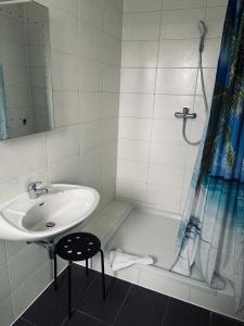 a white bathroom with a sink and a shower at Gästehaus Hanseat in Bremerhaven