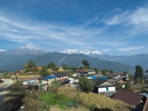 ein Dorf mit schneebedeckten Bergen im Hintergrund in der Unterkunft Hemjakot Community Homestay in Pokhara