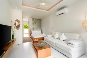 a living room with a white couch and a table at Chi Samui Resort in Bophut