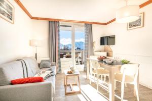 a living room with a couch and a table and a kitchen at Résidence Pierre & Vacances Les Bergers in L'Alpe-d'Huez