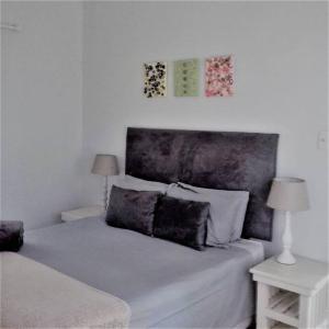 1 dormitorio con 1 cama con 2 mesas y 2 lámparas en Bush house by the sea, Ponta Malongane, en Ponta Malangane