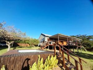 a house with a wooden deck and a fence at Bush house by the sea, Ponta Malongane in Ponta Malongane