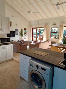 cocina y sala de estar con lavadora en Bush house by the sea, Ponta Malongane, en Ponta Malangane